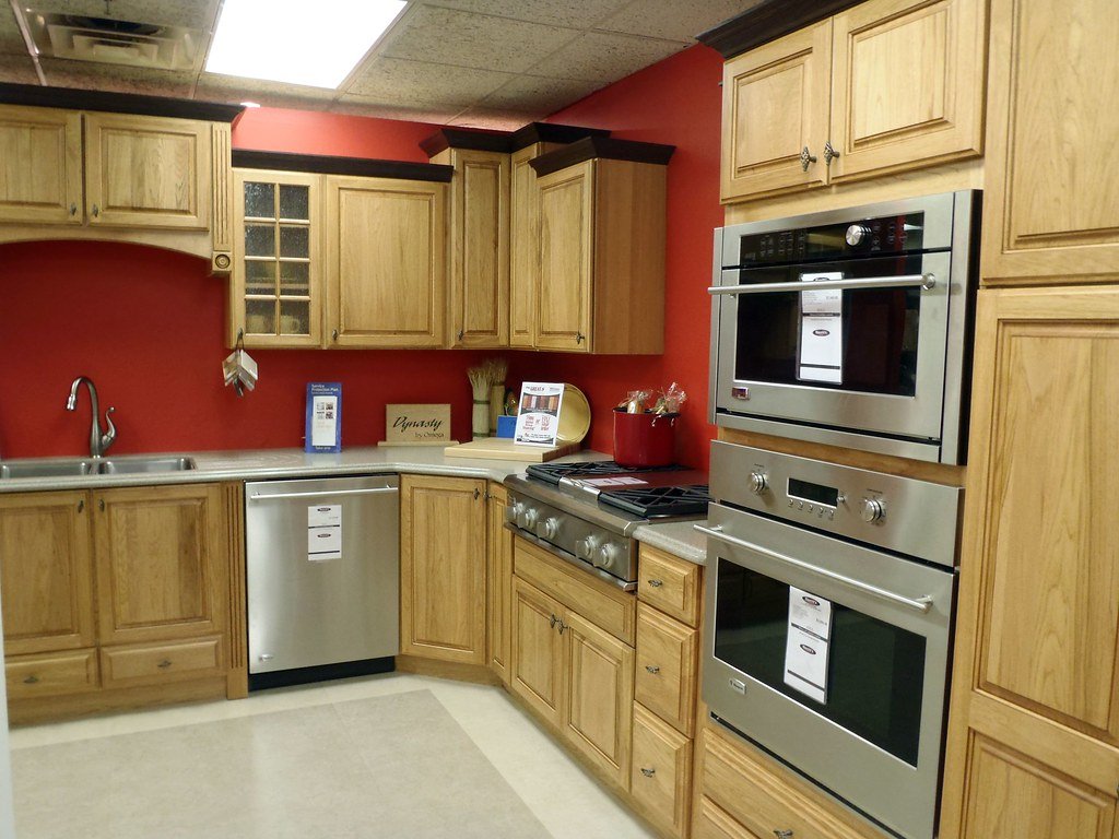 A custom kitchen with wood cabinets, stone counters and built-in wall ovens