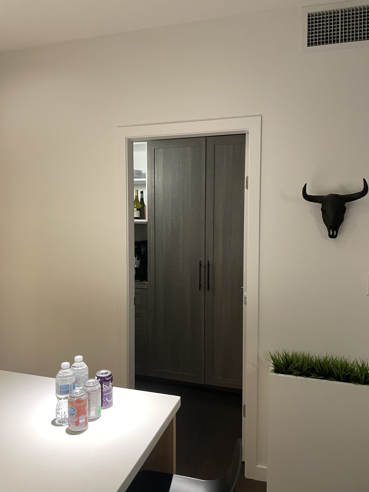 Before: grey hinged doors beside the kitchen island in a Downtown Vancouver loft