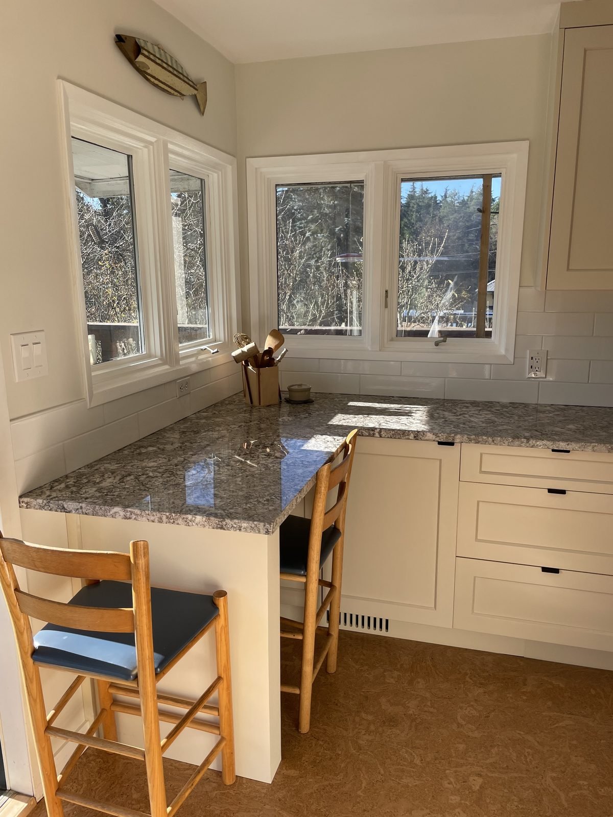 Corner window breakfast bar with granite counter and seating in a renovated Dunbar, Vancouver kitchen