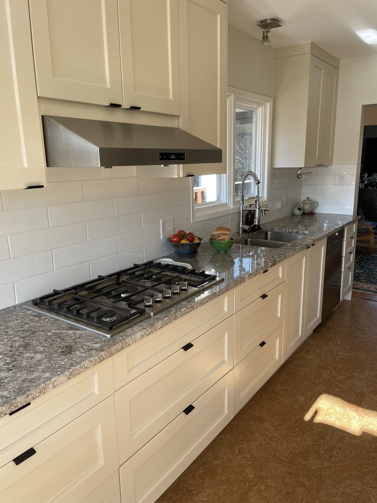 Cream shaker cabinets, grey granite countertops and white subway tile with a gas cooktop in a Dunbar, Vancouver kitchen renovation