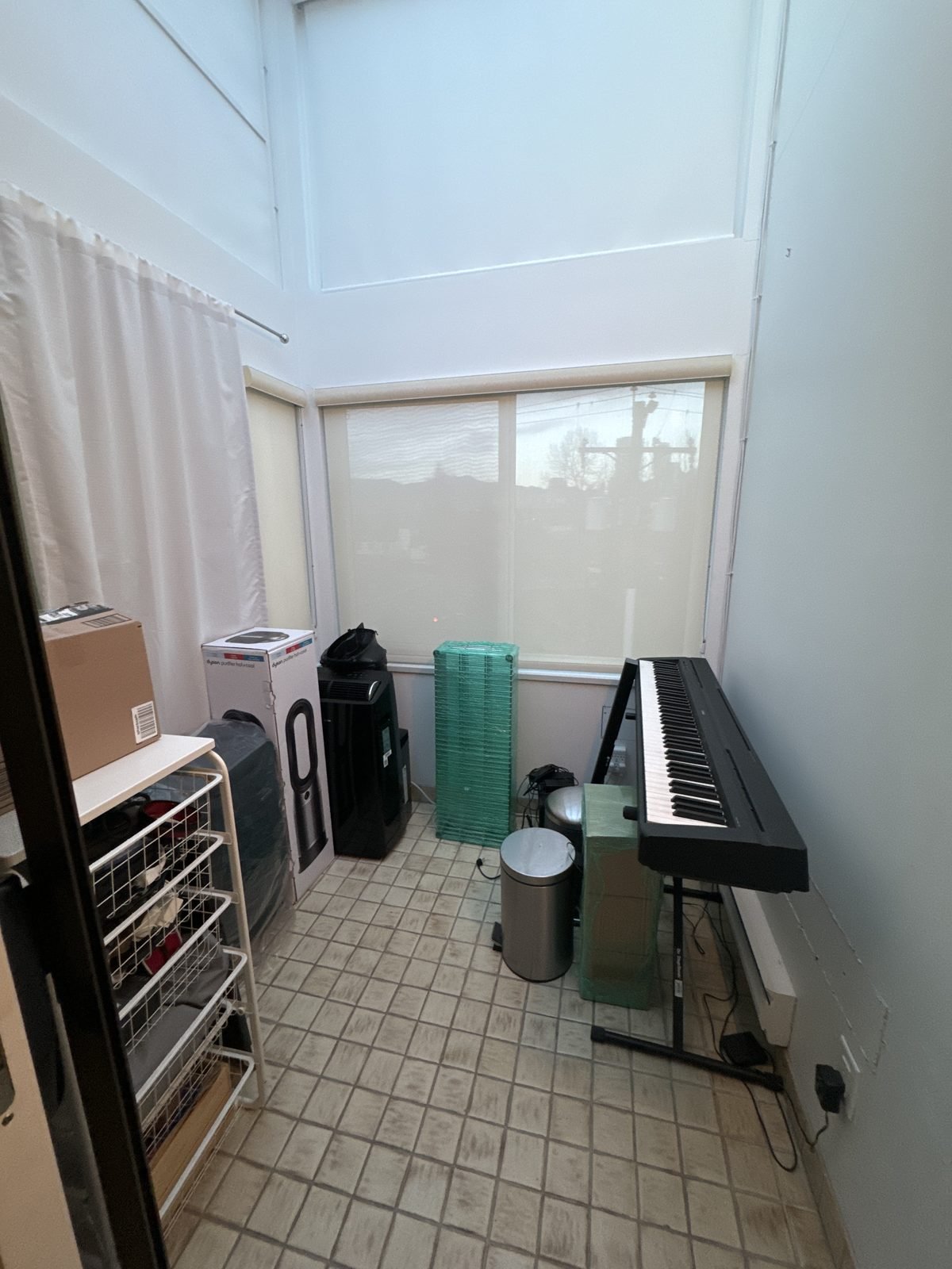 Before: tiled den with a glass ceiling beside the primary bedroom in a Fairview condo