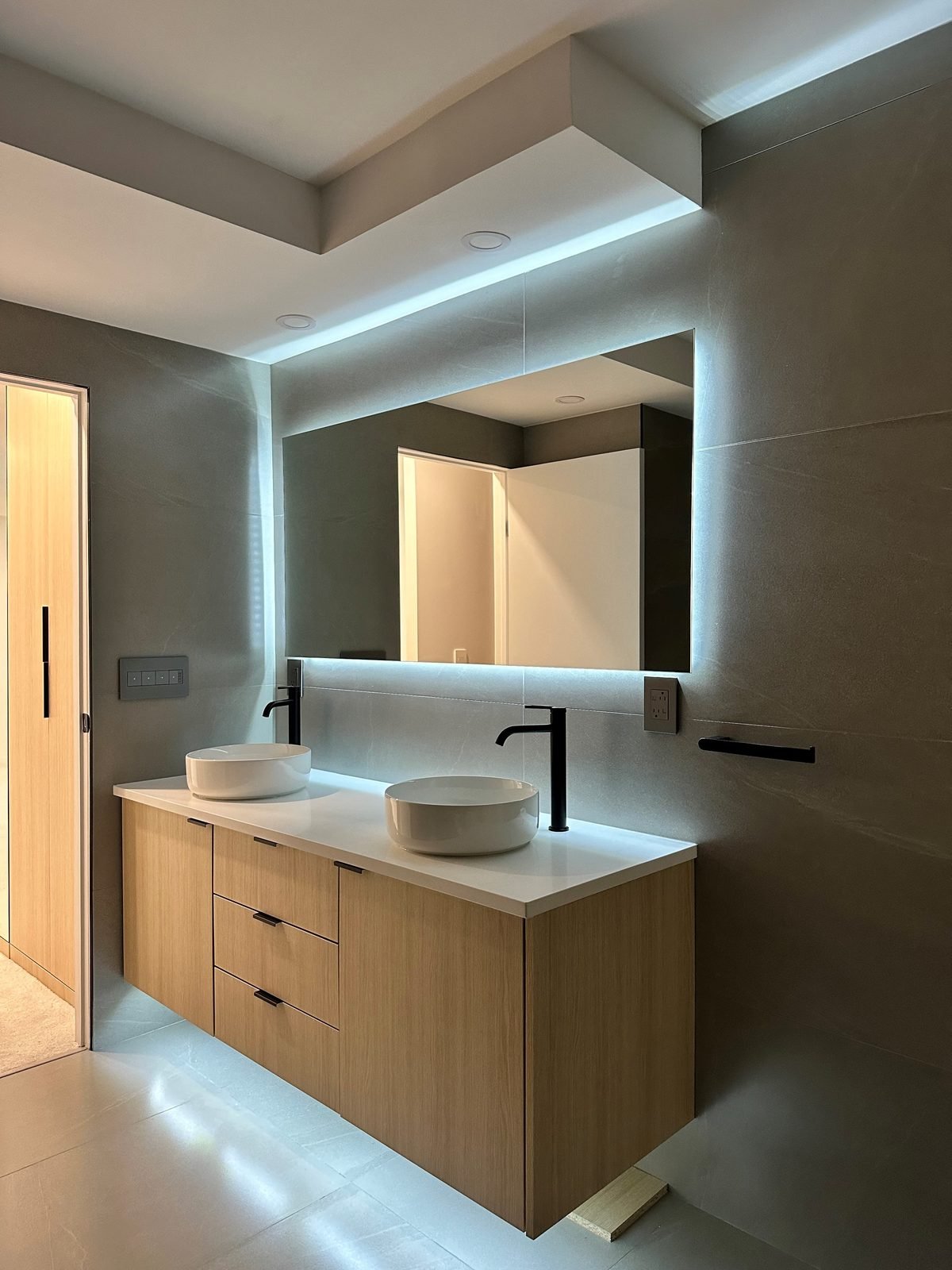 Floating double vanity with LED strip lighting underneath and a lit soffit in a Fairview, Vancouver condo ensuite
