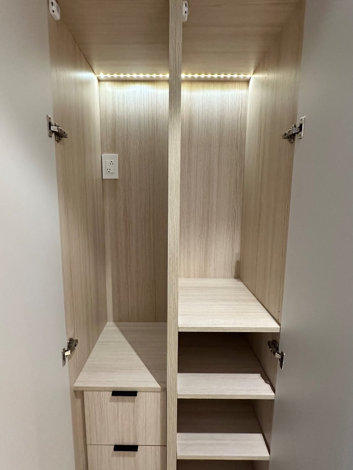 Custom entry built-in closet with wood-grain interior, drawers and LED lighting in a Fairview condo