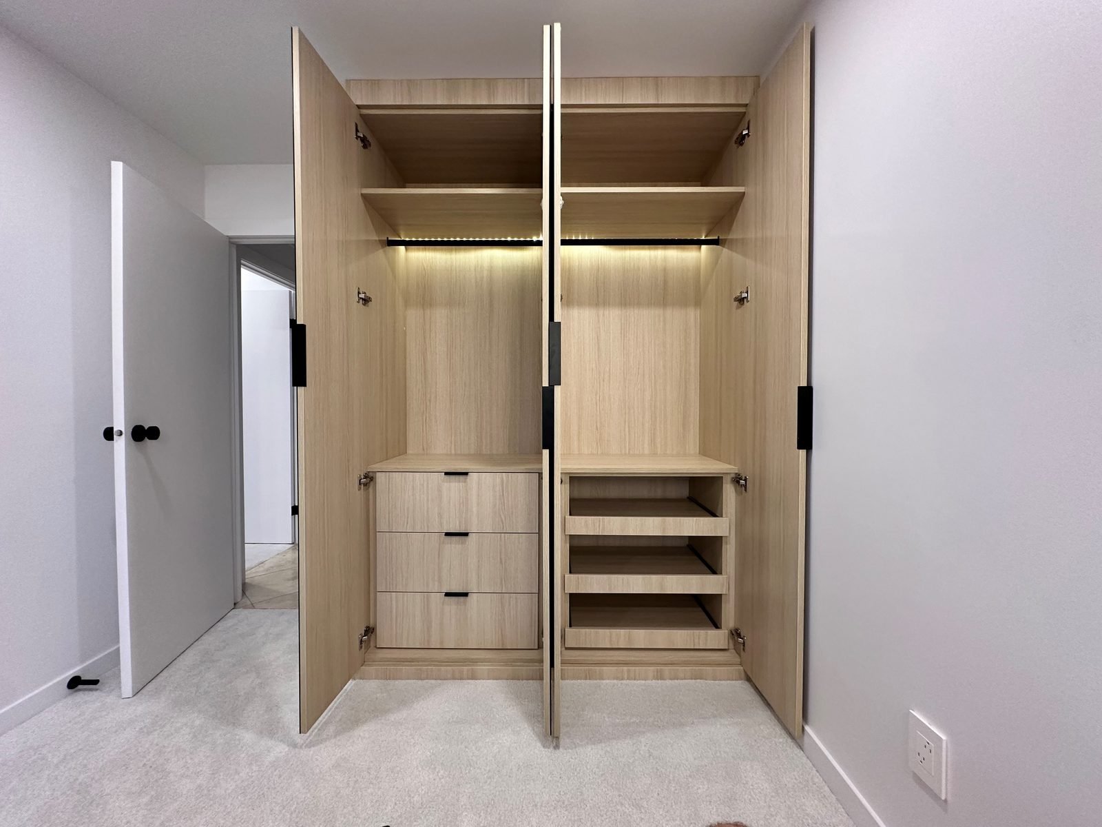 Custom built-in closet with drawers, open shelves and LED lighting in a Fairview condo second bedroom