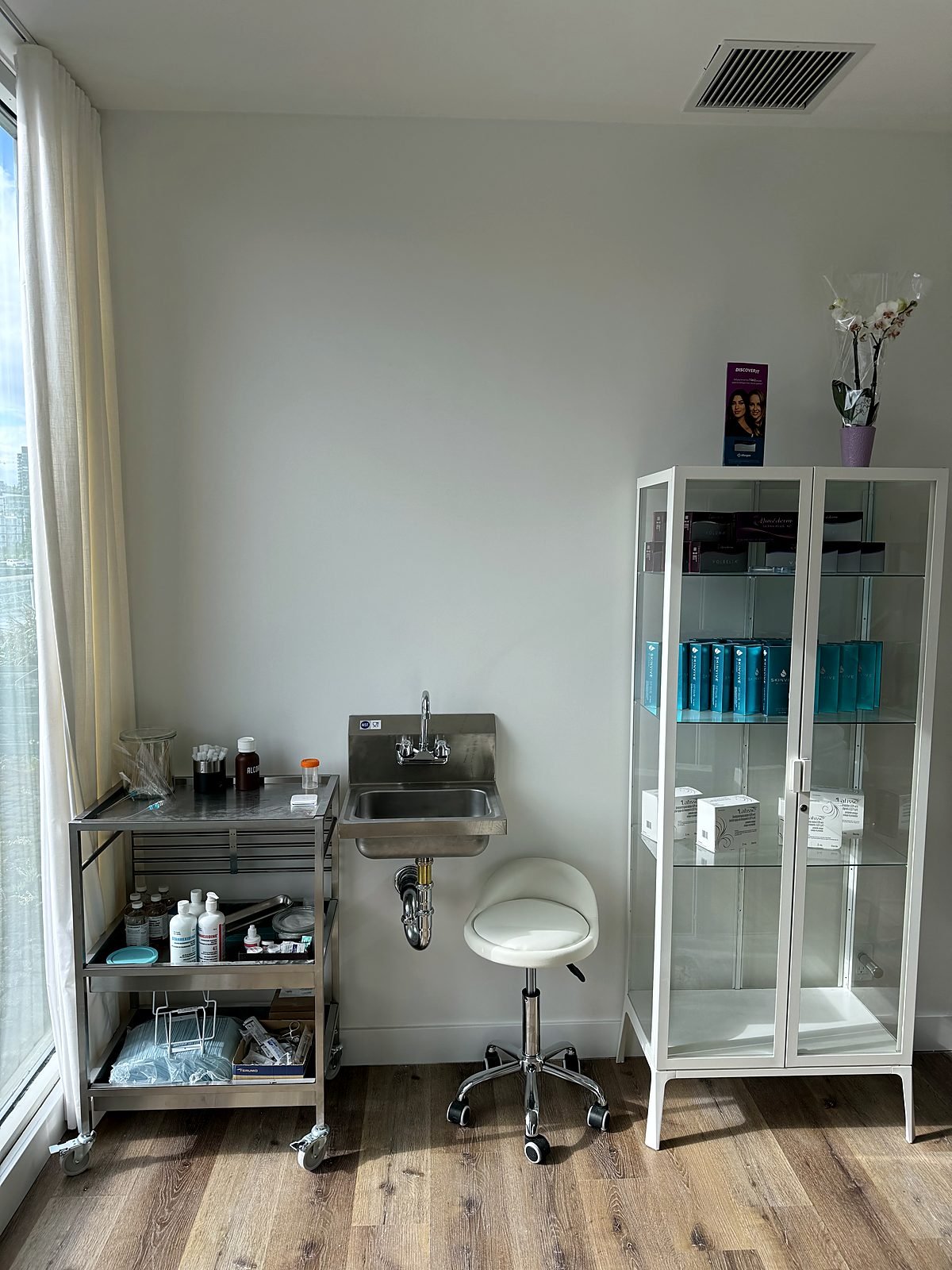 New stainless wall-mount sink and faucet installed in a clinic treatment room