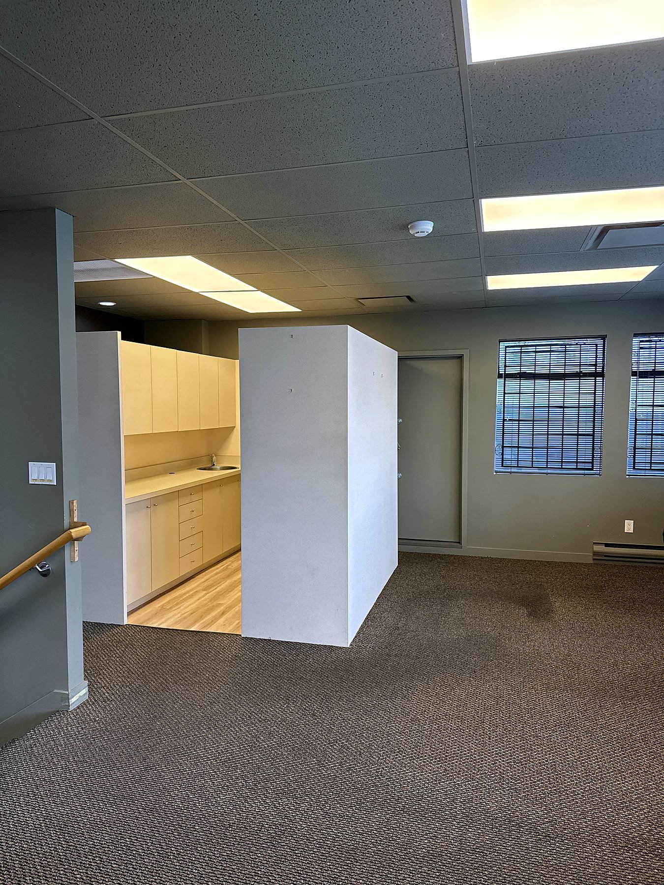 Old upper floor kitchen and worn carpet before the Burnaby office renovation