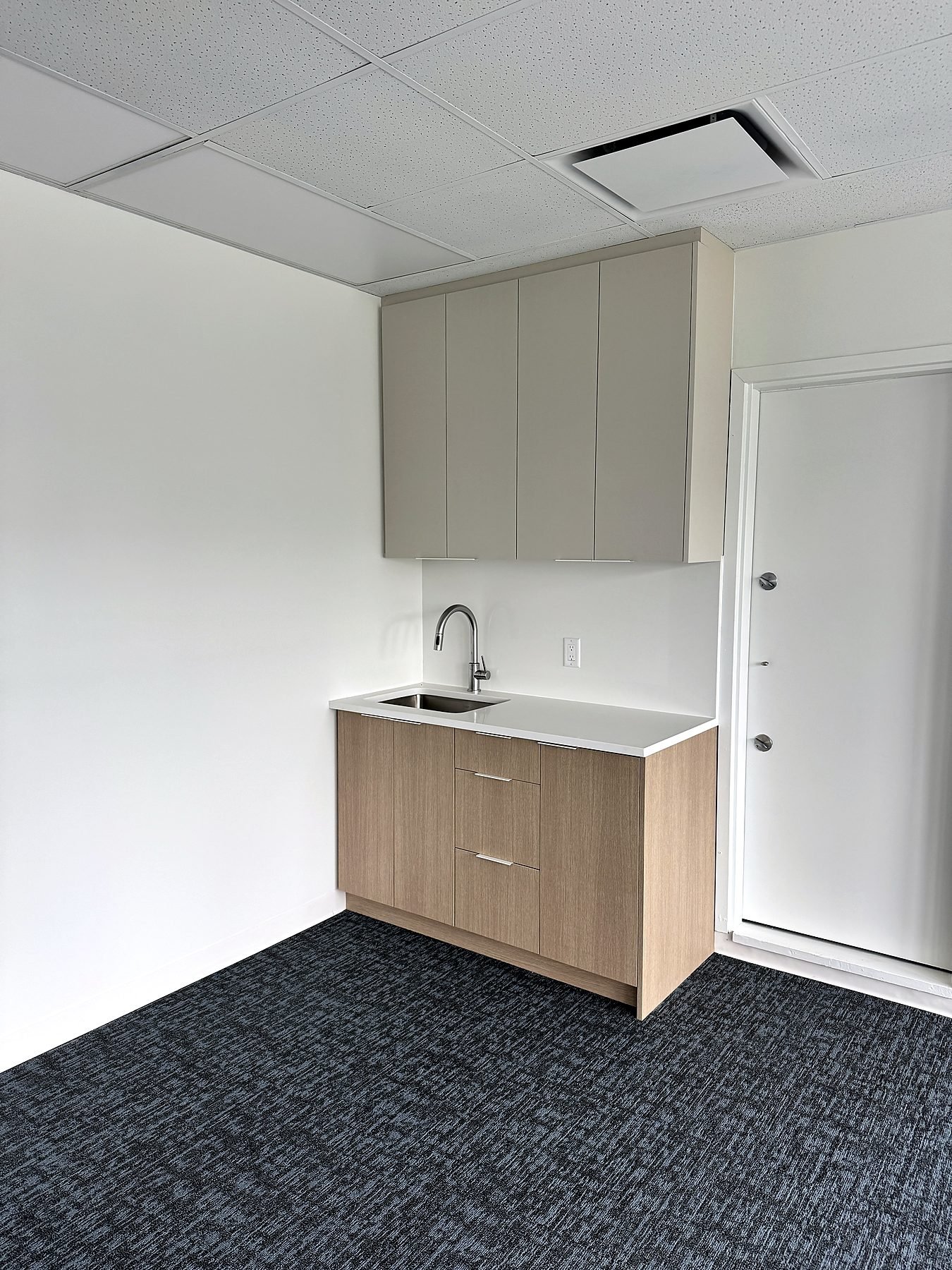 Upper floor coffee bar kitchenette with new cabinetry, quartz counter and carpet tile in a Burnaby office
