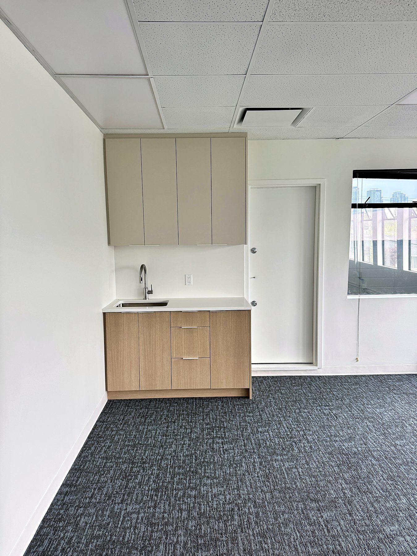Upper floor kitchenette with refreshed T-bar ceiling and new carpet after the Burnaby office renovation