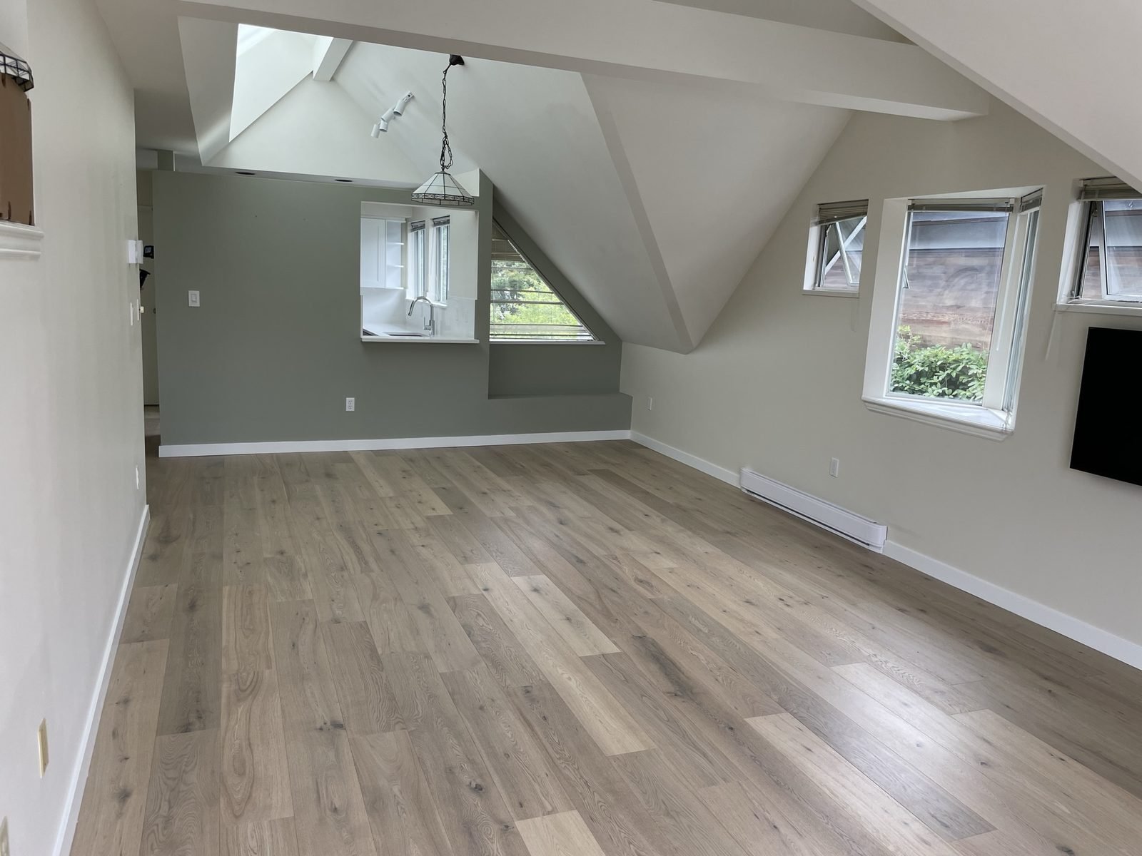New engineered hardwood flooring under vaulted ceilings in a renovated Kitsilano condo