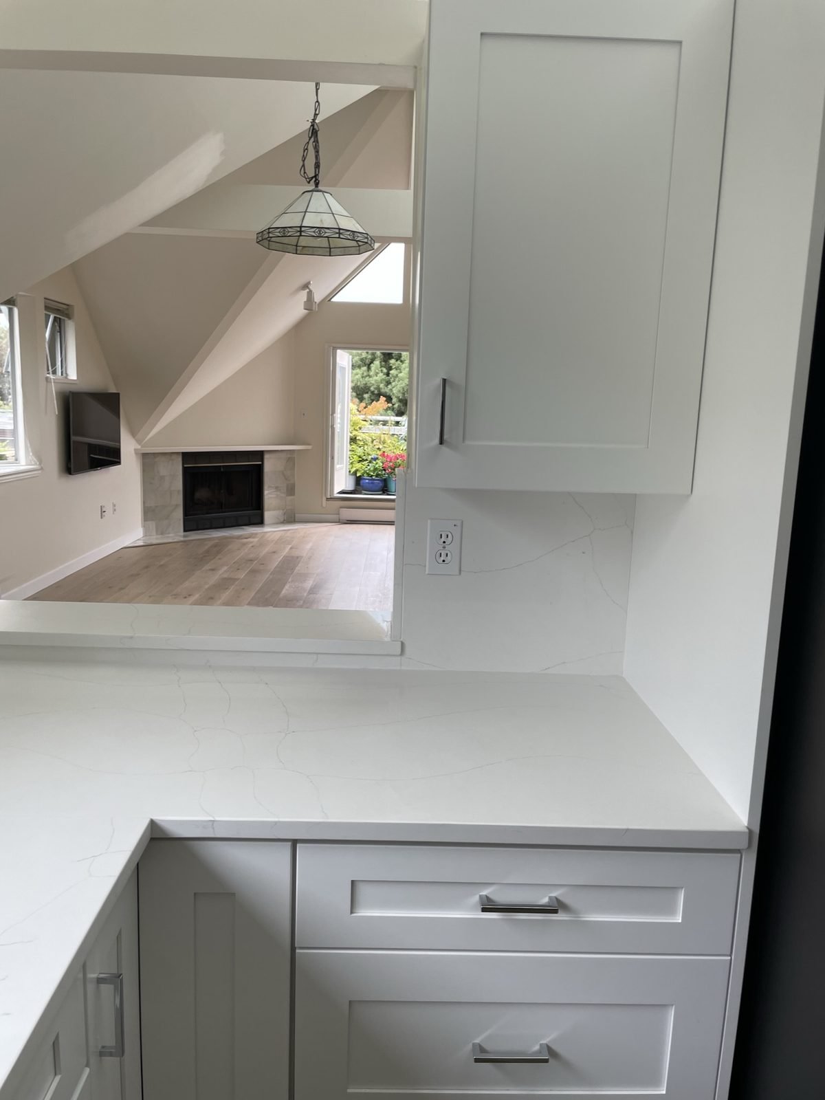 Quartz pass-through counter opening the kitchen to the living room in a Kitsilano condo renovation