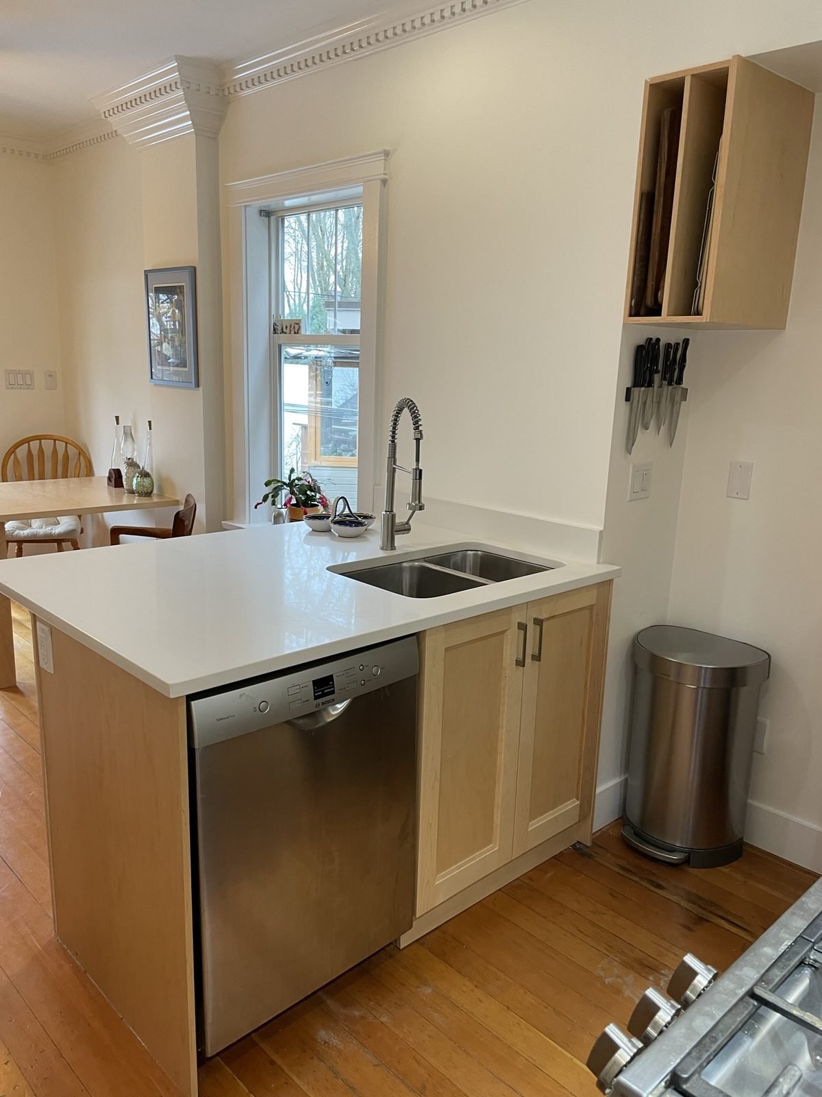 Maple island with undermount double sink, pull-down faucet and dishwasher in a Kitsilano kitchen