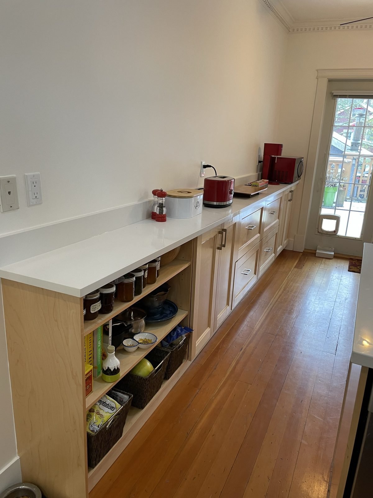 Custom kitchen extension with open maple shelving and quartz counter along the dining wall in a Kitsilano home