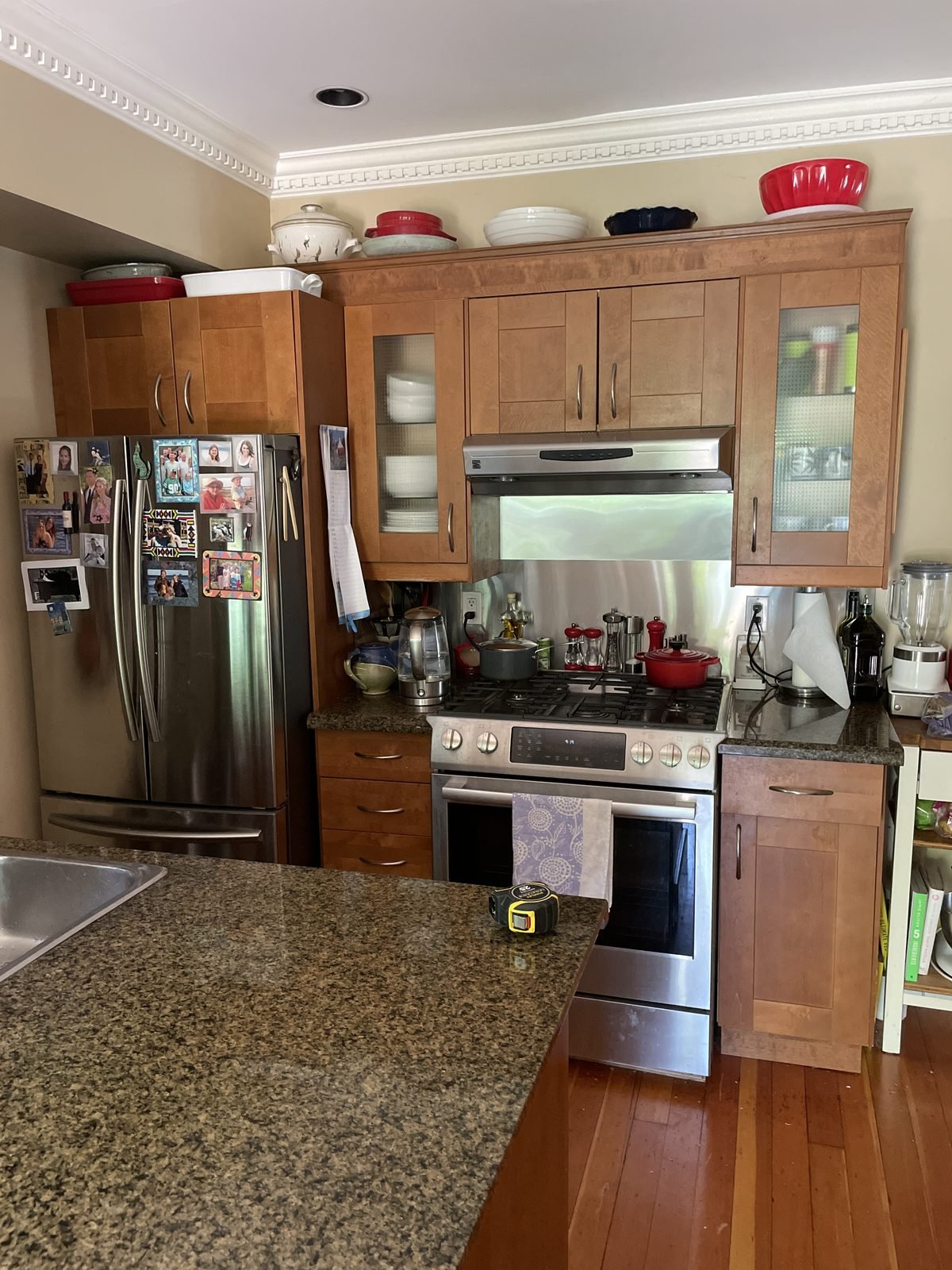 Before: cherry-stained cabinets and dark granite around the range in a Kitsilano, Vancouver kitchen