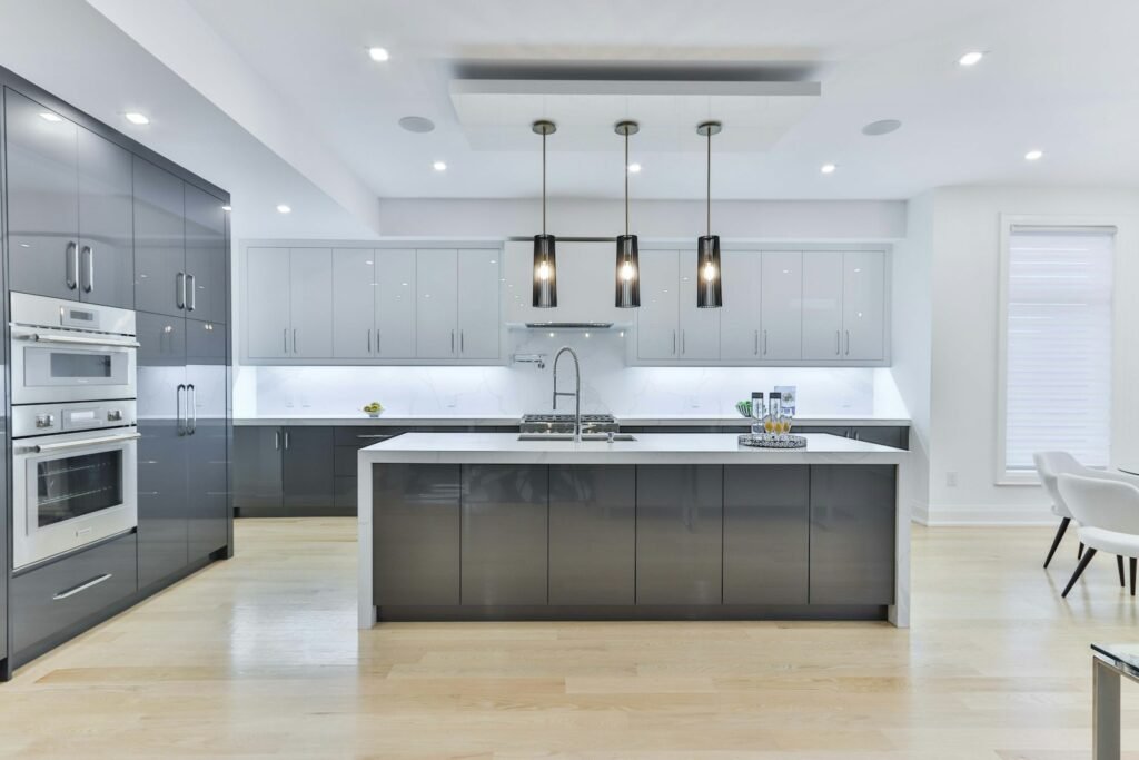 Modern kitchen with grey cabinets, white island and pendant lights