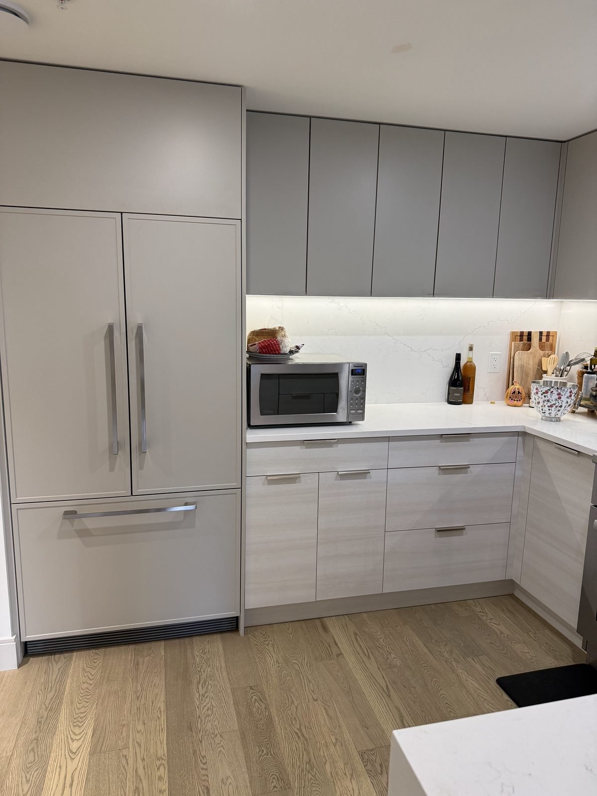 Panel fridge, new lower cabinet fronts and quartz counters in a renovated North Vancouver kitchen