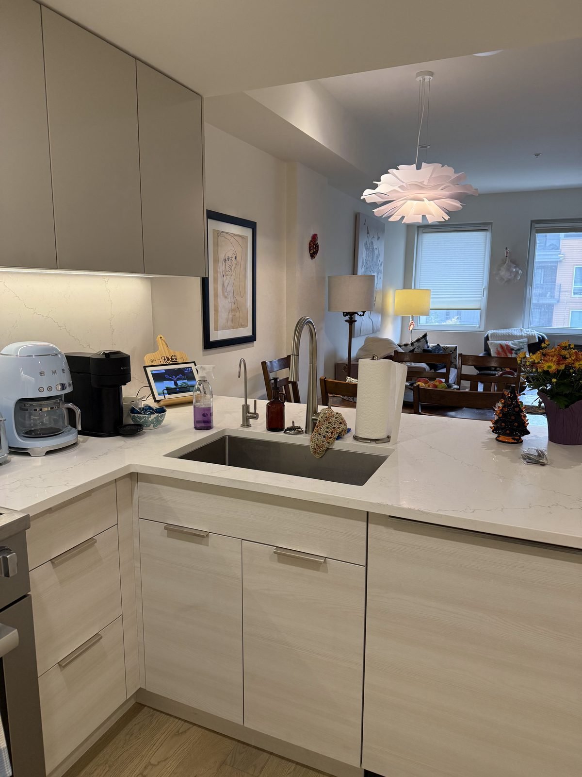 Peninsula sink and white quartz counters opening to the dining area in a Moodyville kitchen renovation