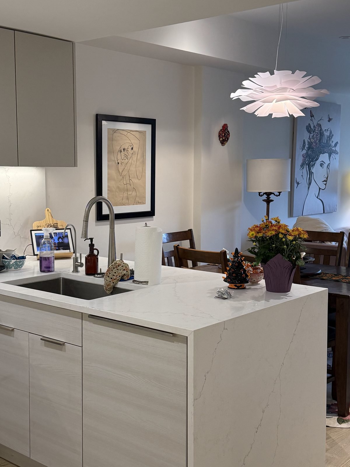 White quartz waterfall peninsula with undermount sink after a partial kitchen renovation in Moodyville, North Vancouver