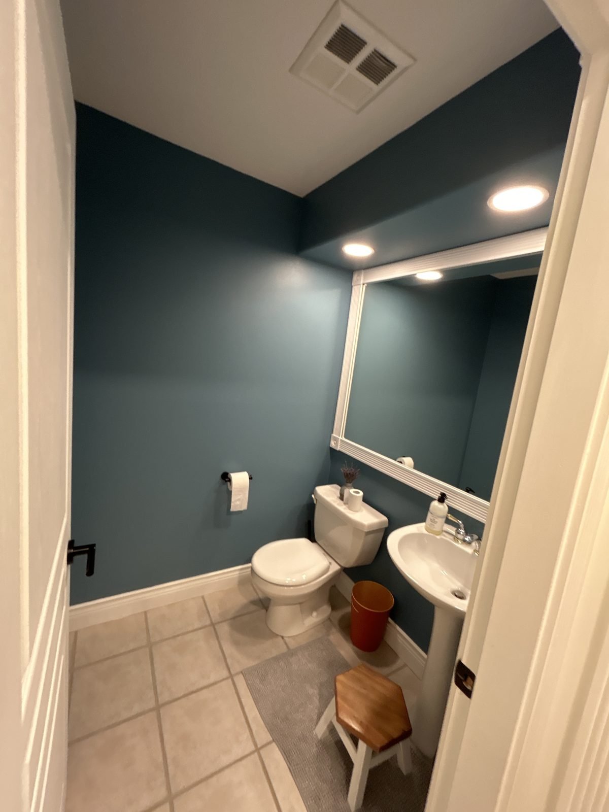 Before: powder room with a pedestal sink and beige floor tile in a North Vancouver townhouse
