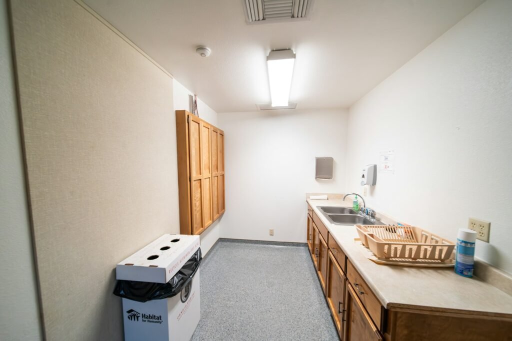 Bright office kitchen with sink and refrigerator