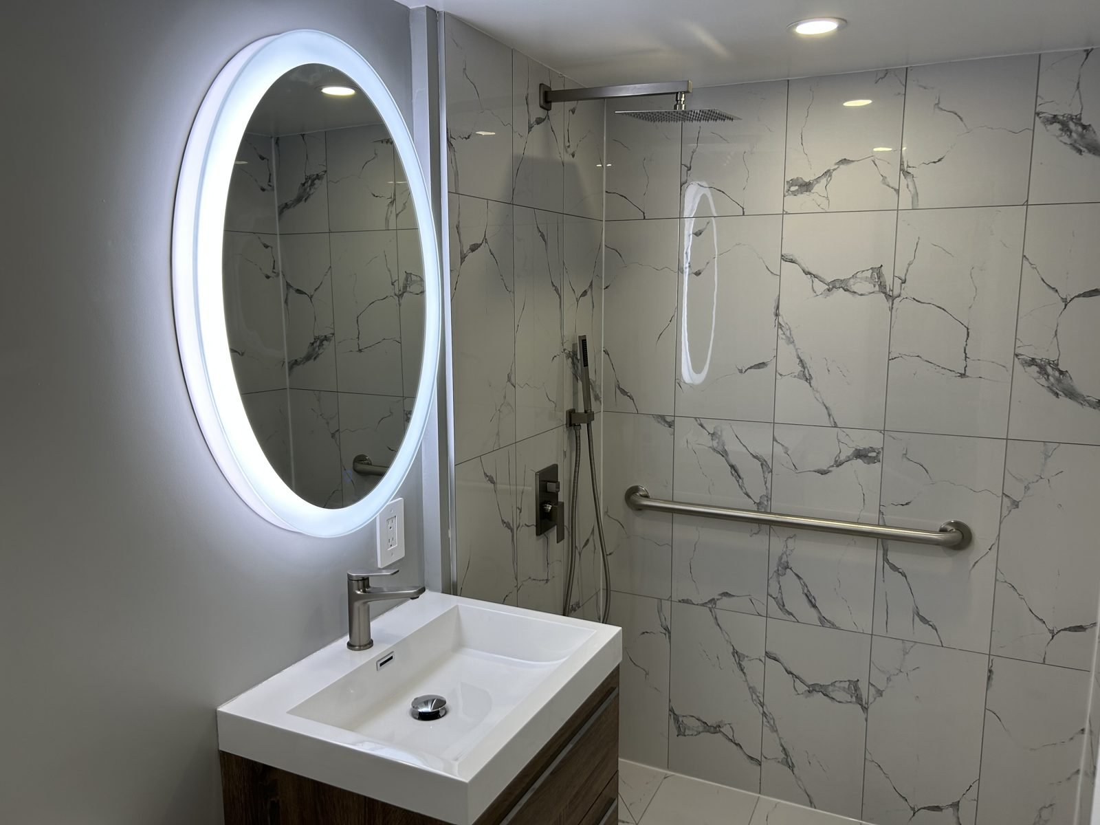 Accessible ground-floor bathroom with a curbless walk-in shower, grab bar and floating vanity in a Shaughnessy townhouse