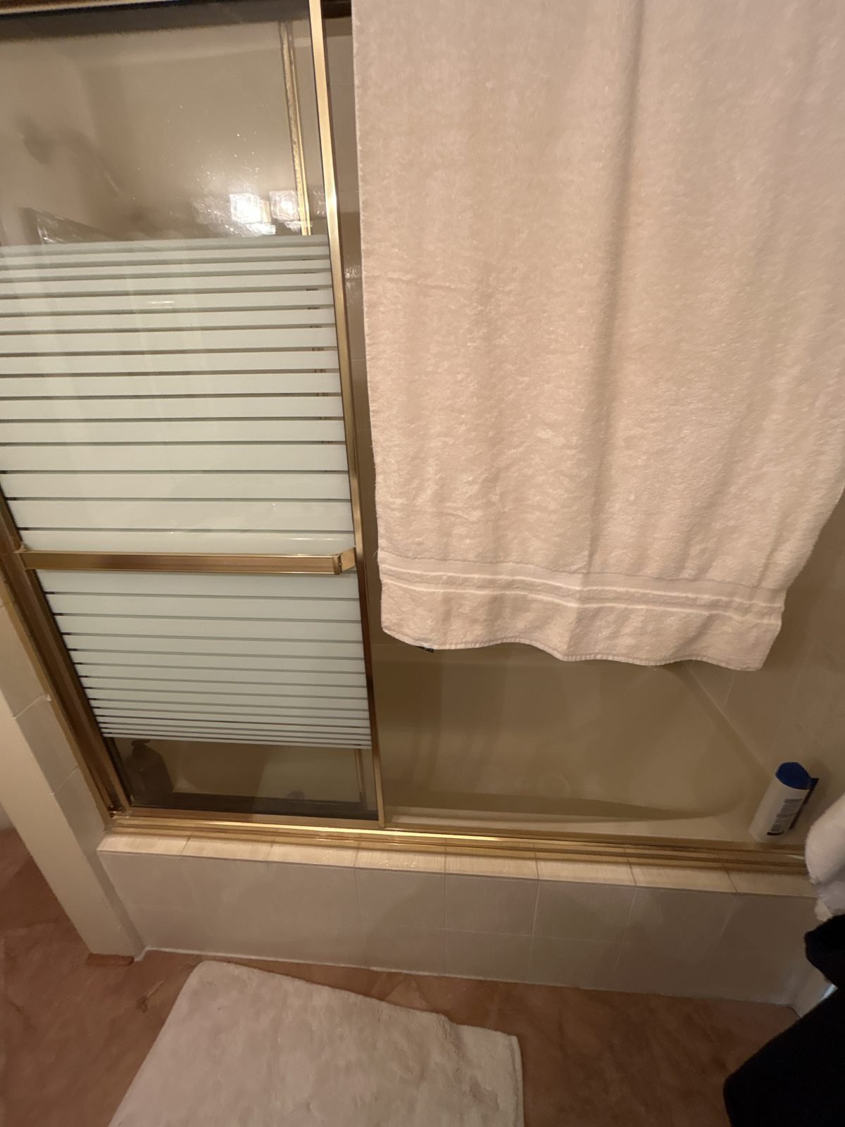 Before: tub with a sliding glass door in a dated Shaughnessy townhouse bathroom