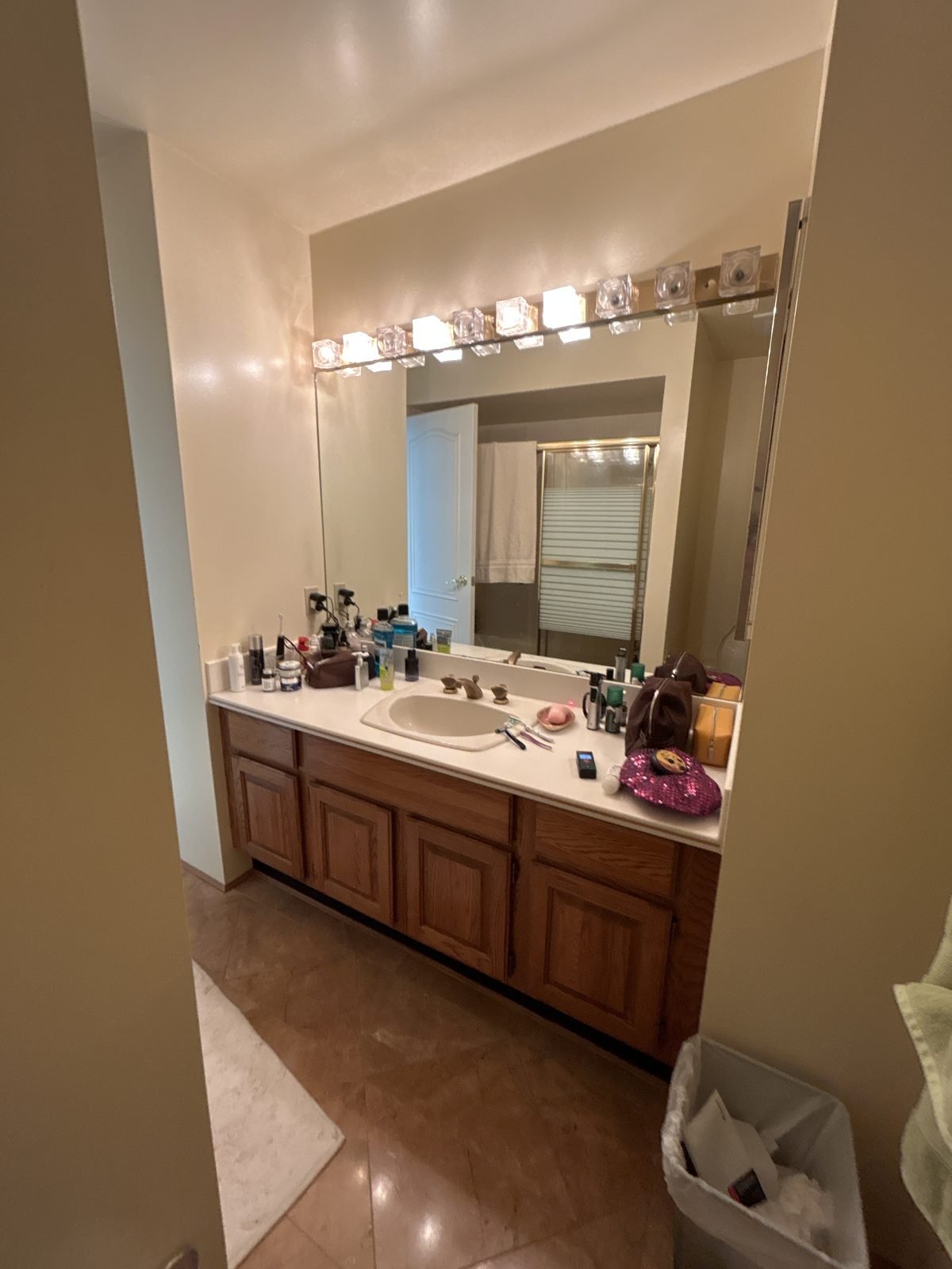 Before: dated main bathroom with a long oak vanity and Hollywood lights in a Shaughnessy townhouse