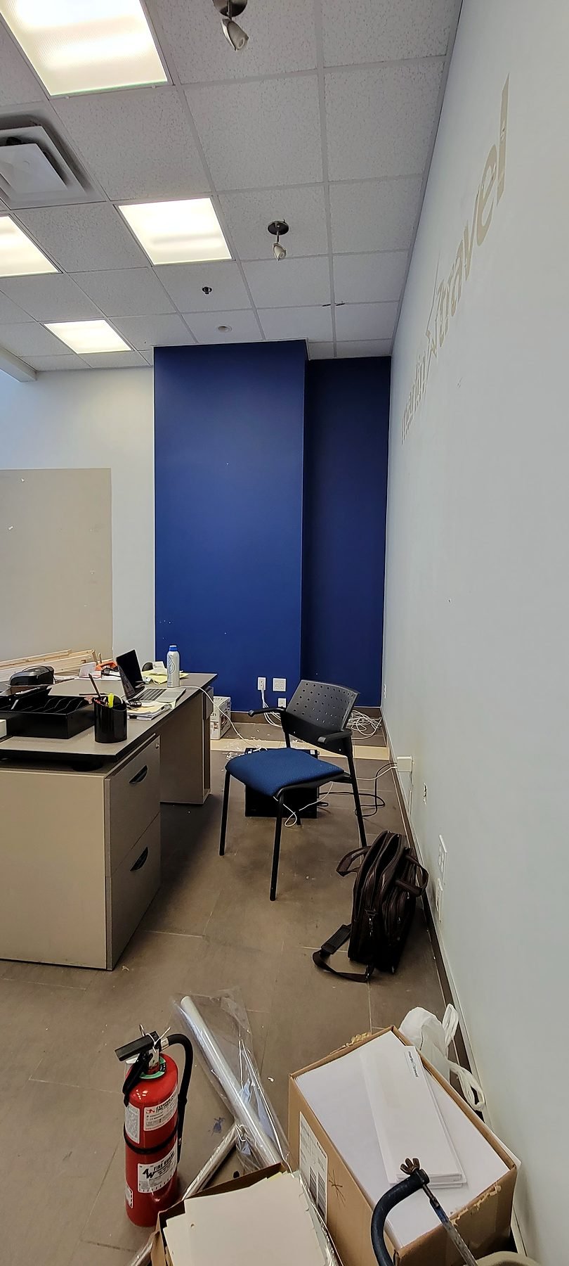 Old back office with a blue accent wall before the retail store renovation