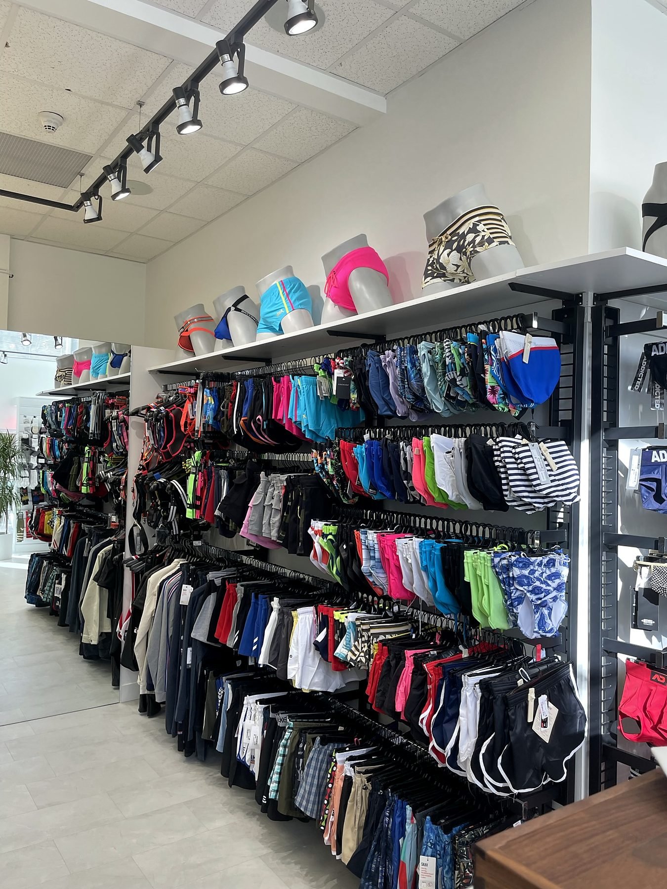 Retail shelving and black suspended track lighting in a renovated Vancouver clothing store