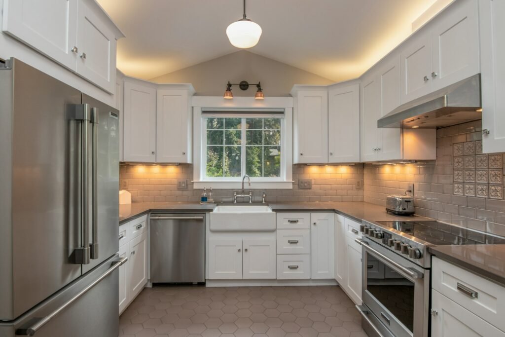 Transitional kitchen with white cabinets and steel appliances