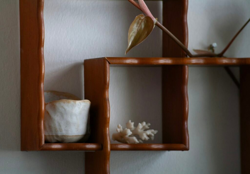 Simple wooden shelf with flowers and a vase