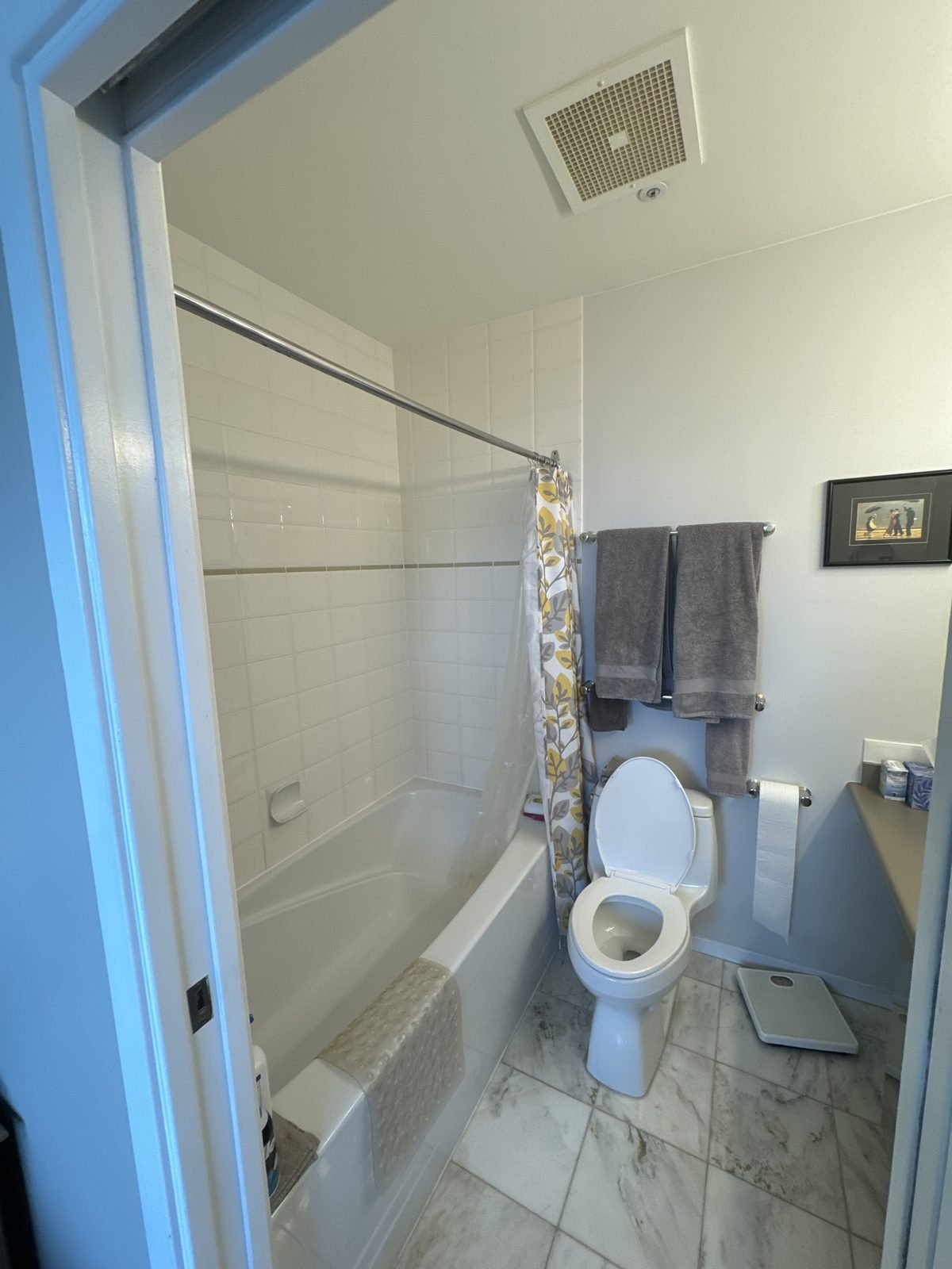 Before: tub with sliding glass doors in a West End condo ensuite