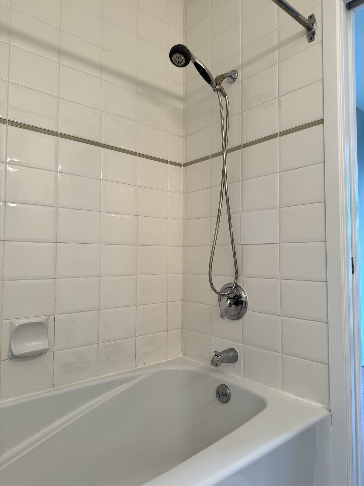 Before: original tub and tiled surround in a West End condo ensuite