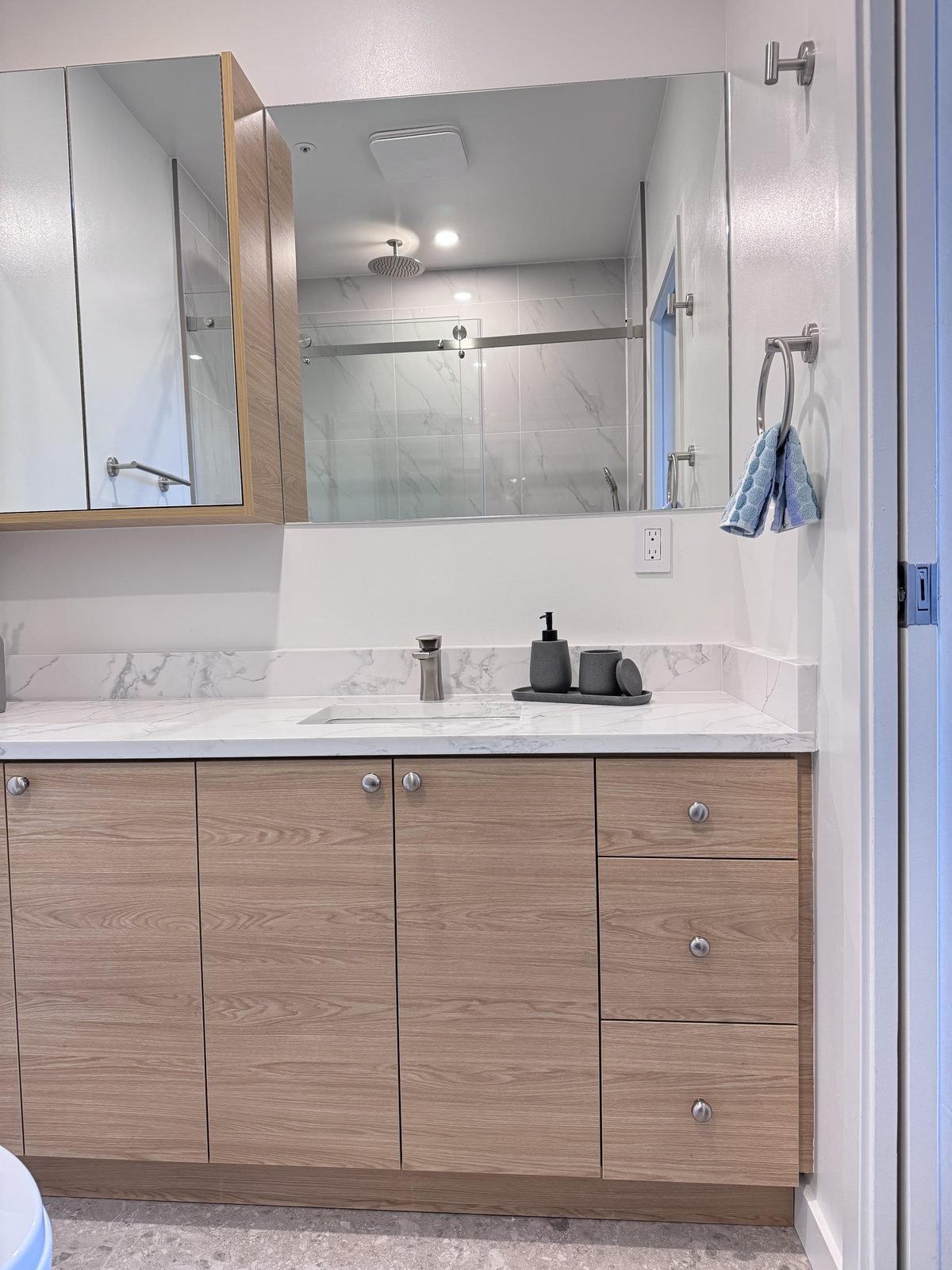 West End condo ensuite with a wood-grain vanity and medicine cabinet