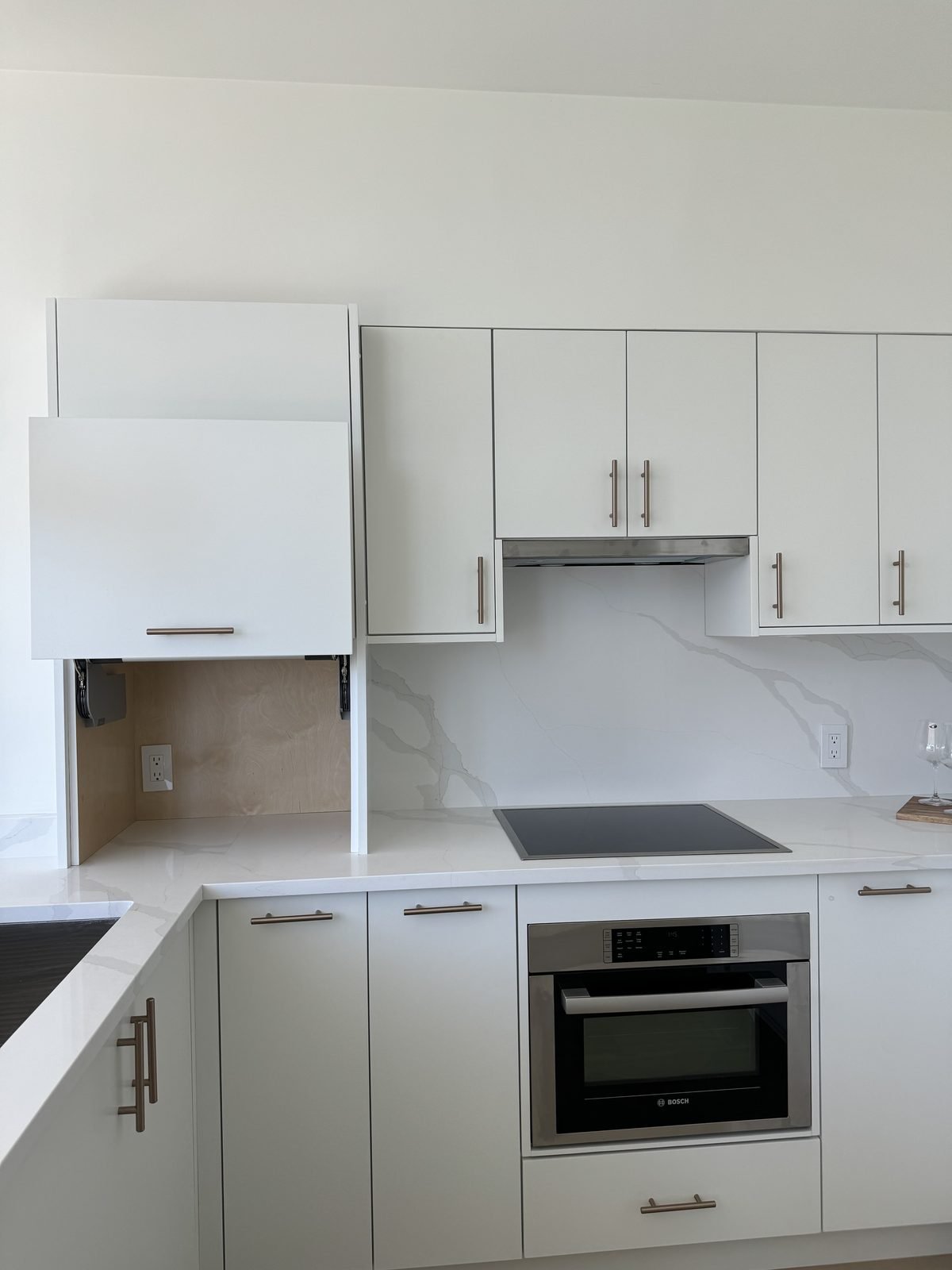 Appliance garage with a lift-up door beside the cooktop in a renovated West End condo kitchen