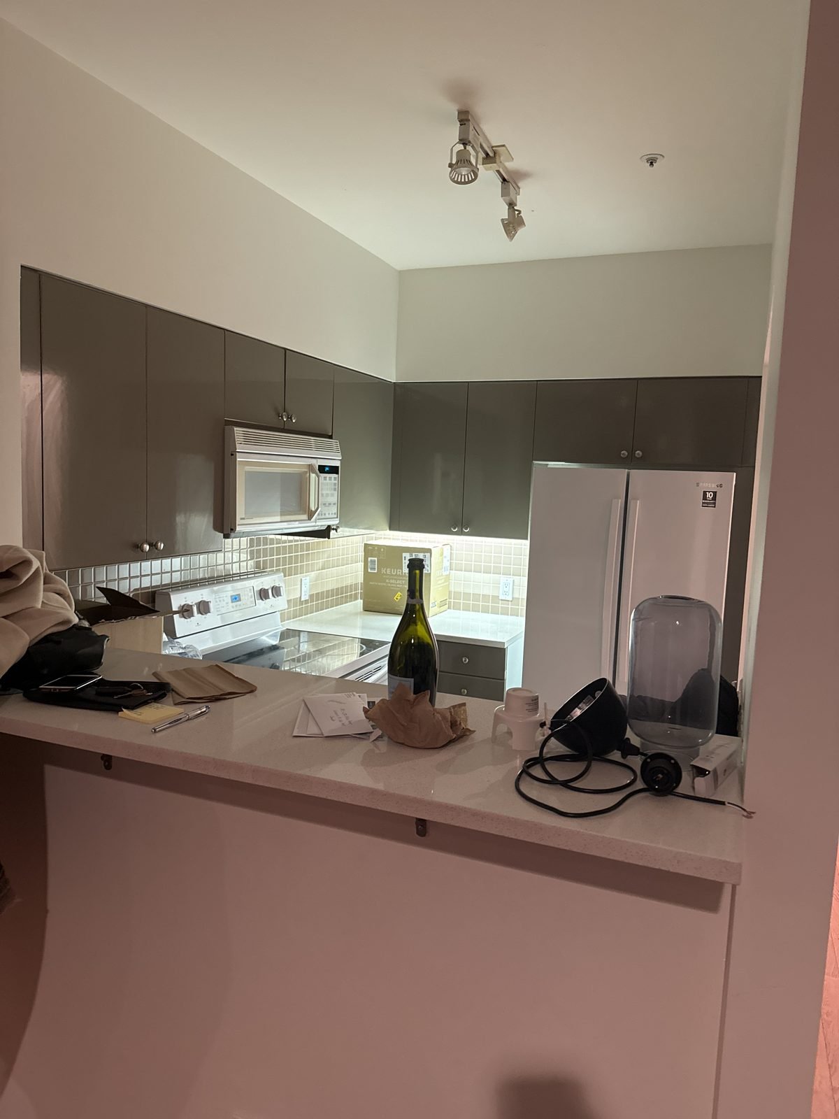 Before: closed condo kitchen with a raised breakfast bar and dark cabinets in a West End condo