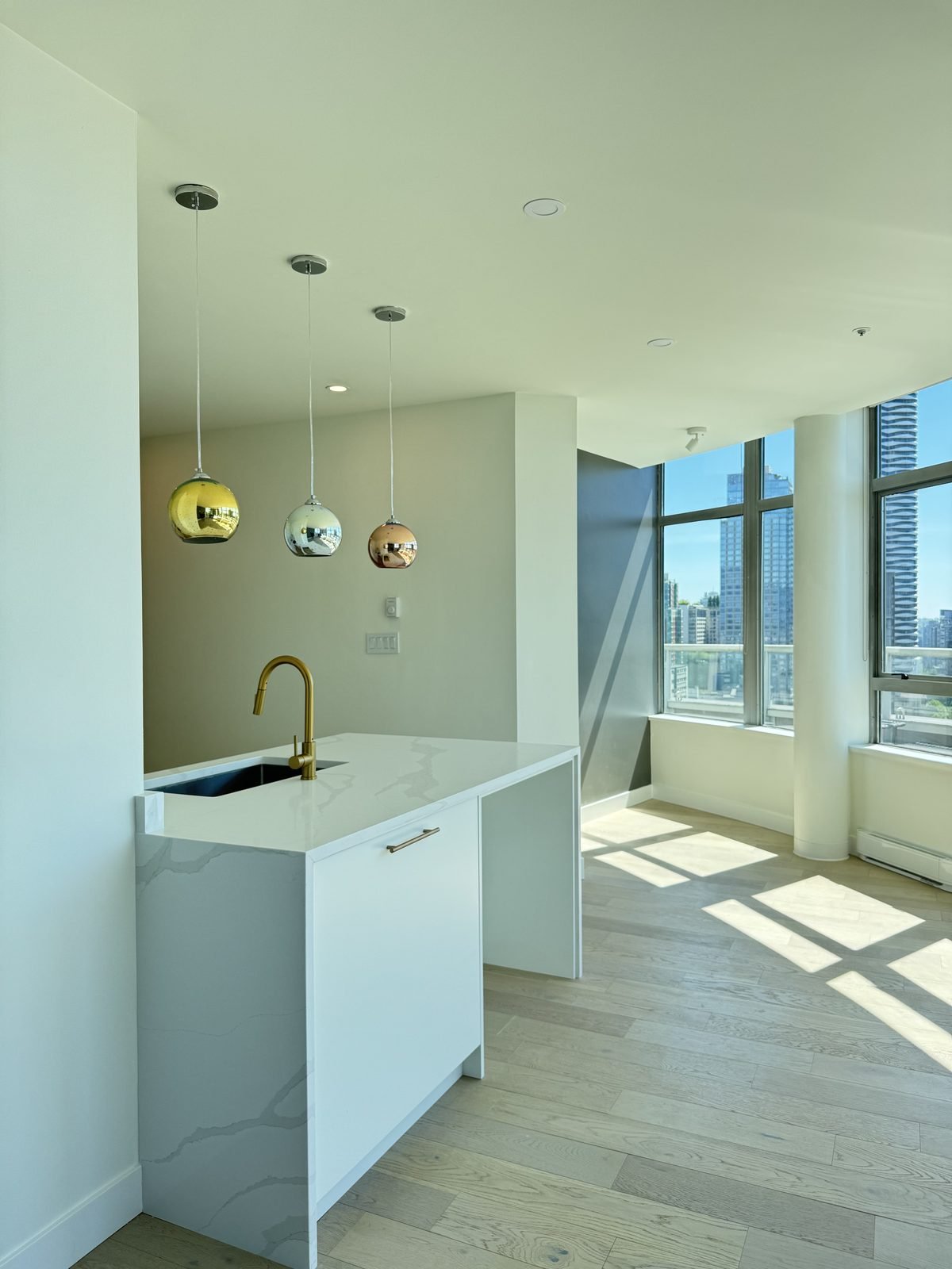 Waterfall island looking out to floor-to-ceiling windows and city views in a West End, Vancouver condo