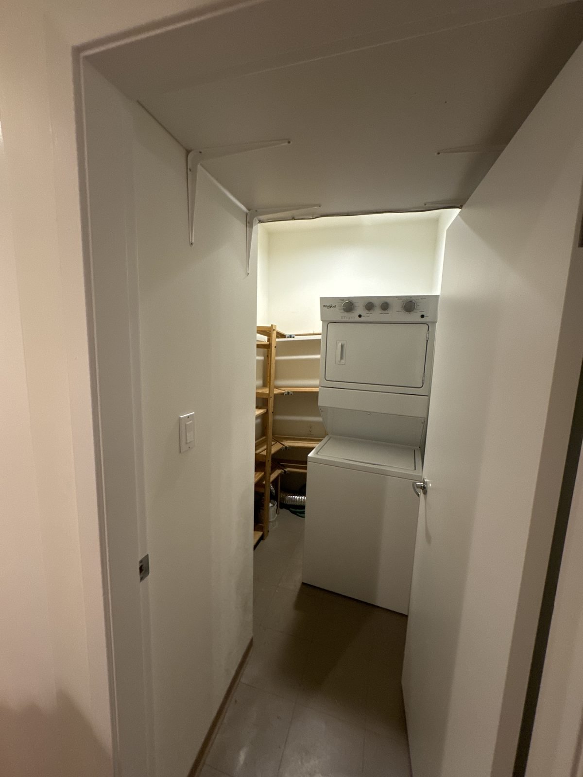 Before: stacked washer and dryer in a small laundry closet in a West End condo