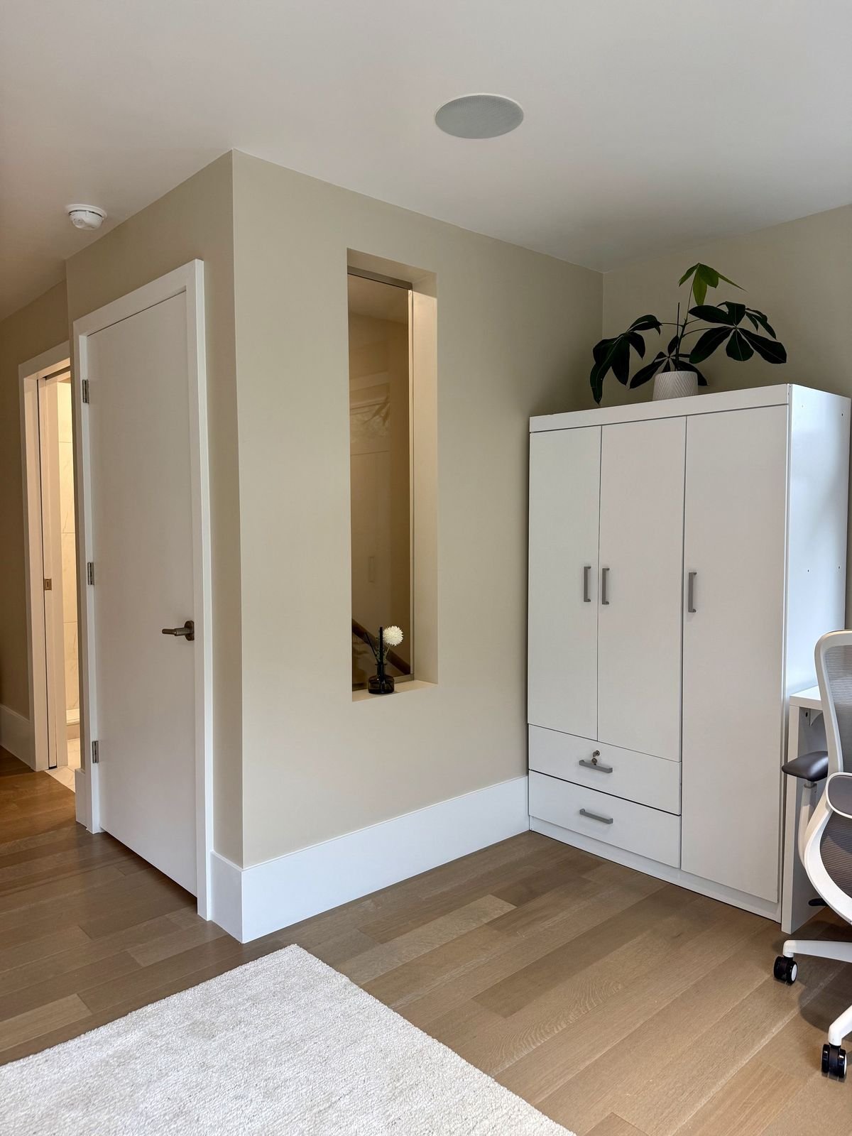 After: new bedroom wall with a door, a lit glass opening to the stairwell and a wardrobe in a West Vancouver loft