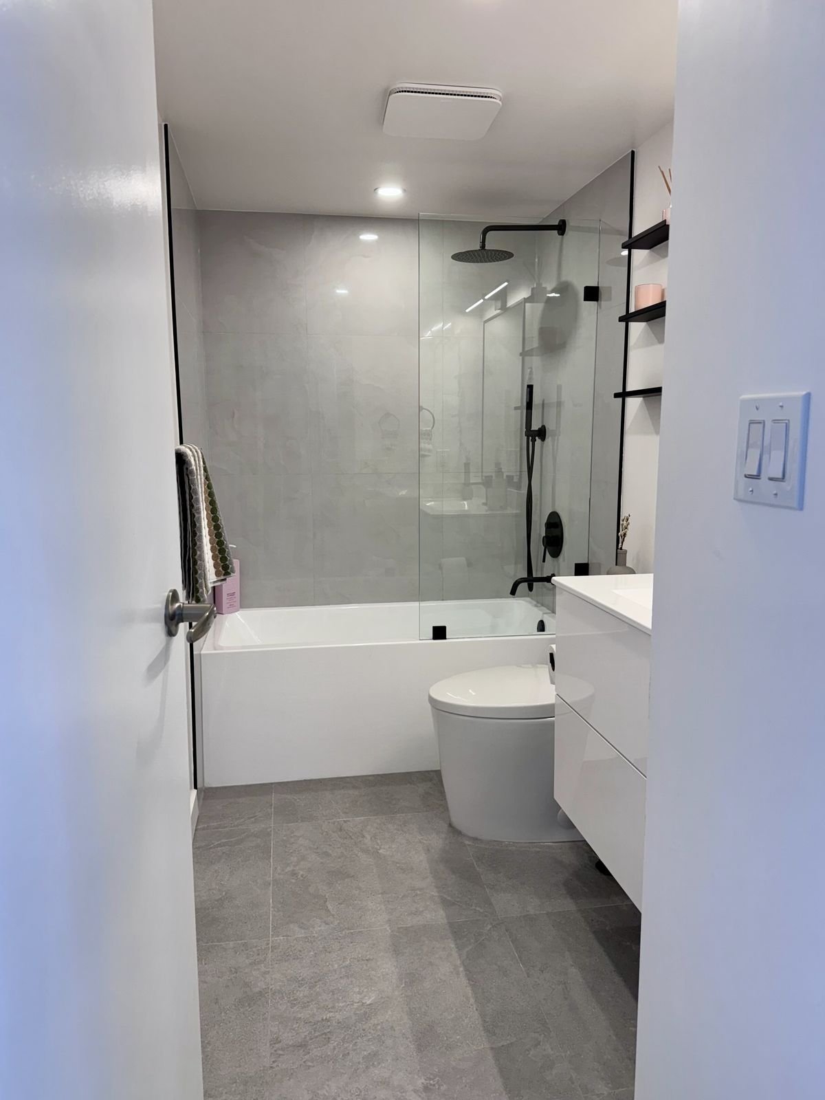 Alcove bathtub with large-format 12x24 tile in a renovated Yaletown condo bathroom