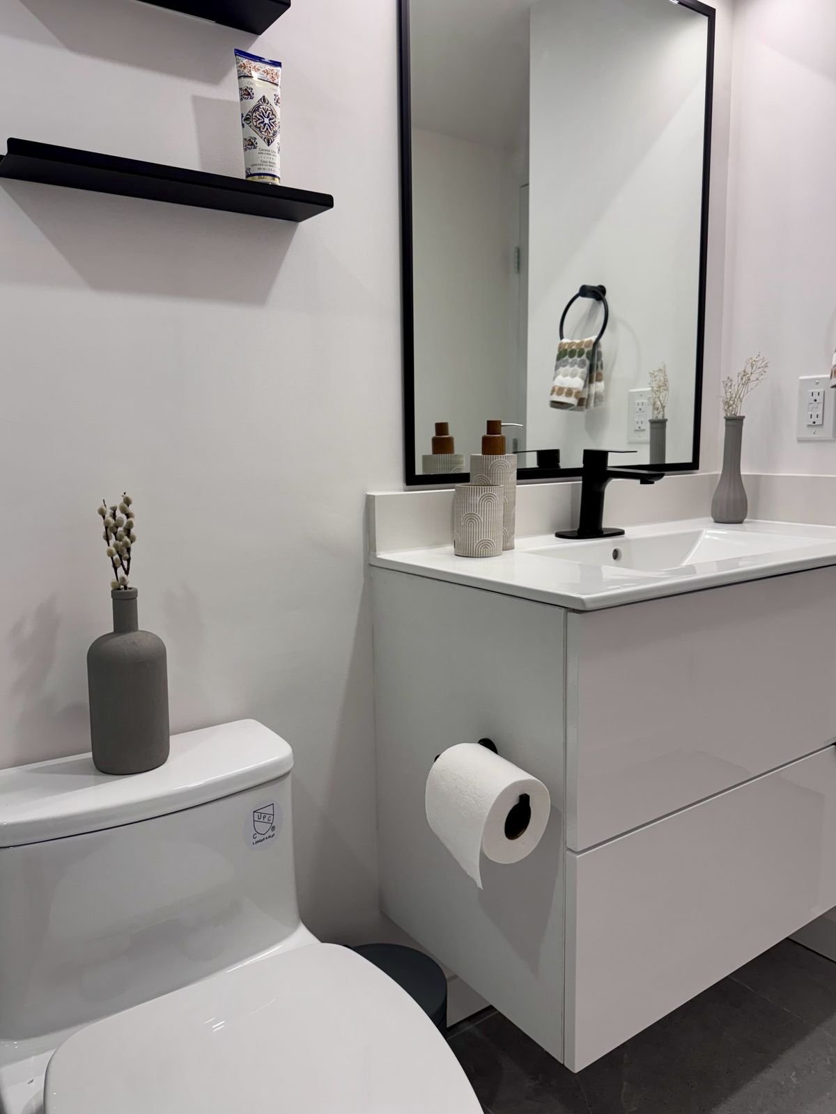 One-piece toilet beside a white floating vanity in a renovated Yaletown condo bathroom