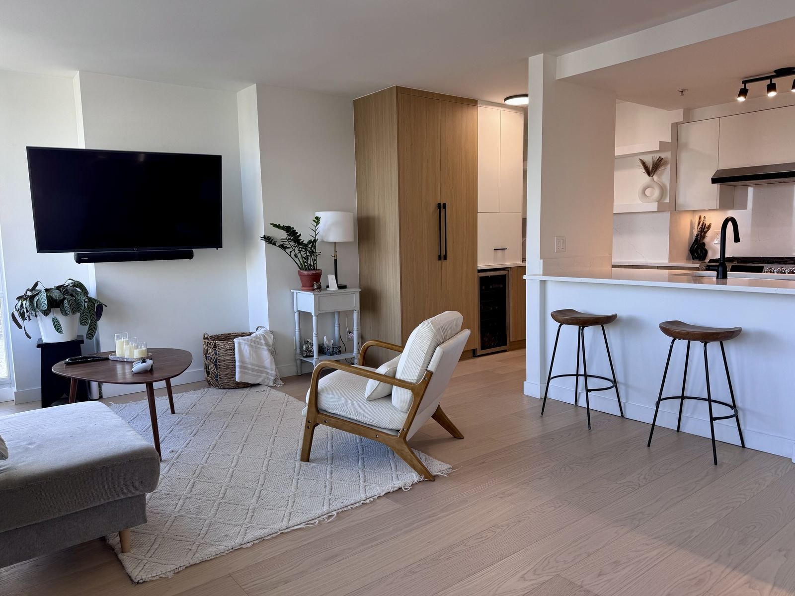 After: Yaletown condo kitchen opened to the living room with a double-sided quartz peninsula