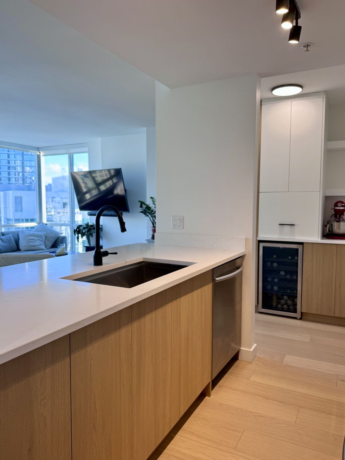 Quartz peninsula with an undermount sink and black faucet in a Yaletown condo kitchen
