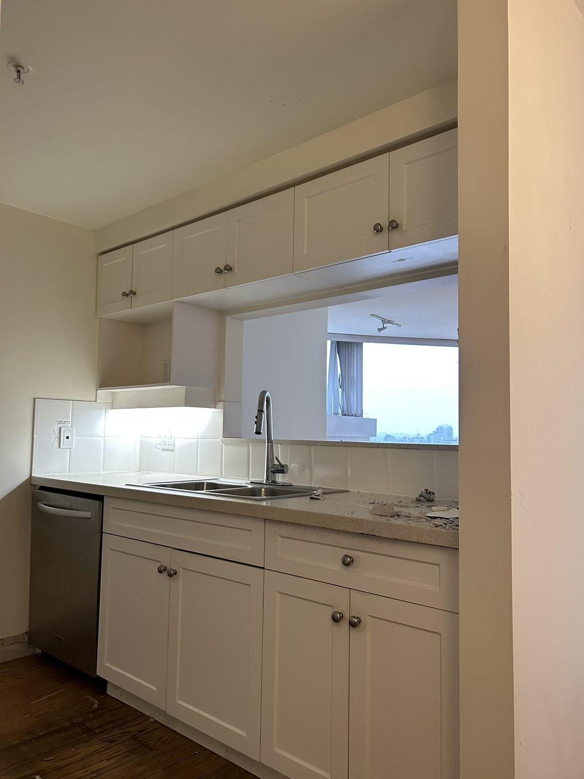 Before: narrow galley kitchen with white shaker cabinets in a Yaletown, Vancouver condo